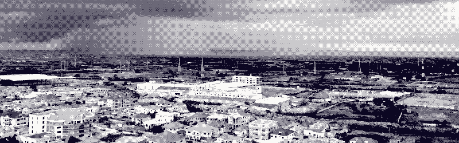 Low-rise Accra under a heavy storm front, a bright band of horizon held between the city and the cloud